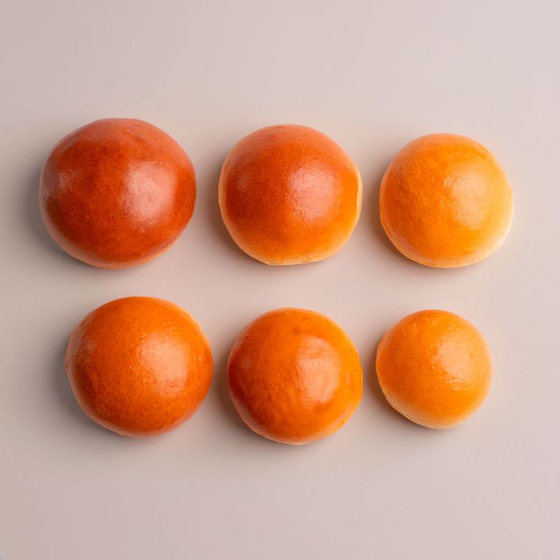 Plain burger buns in several sizes, arranged in two rows